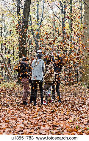 Girls playing with leaves in autumn forest View Large Photo Image Stock Image - Girls playing with leaves in autumn forest. Fotosearch