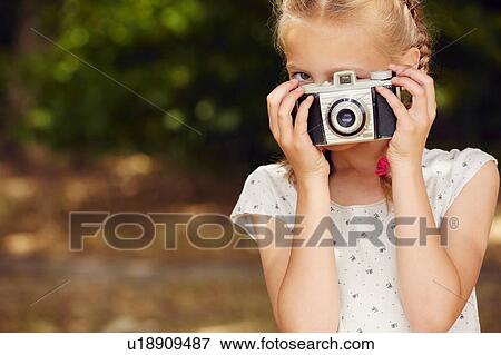 Girls using film camera, looking at camera face obscured View Large Photo Image Stock Photo - Girls using film camera, looking at camera face obscured. Fotosearch