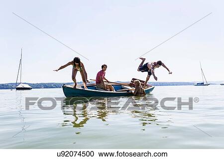 Group of friends diving from boat into lake, Schondorf, Ammersee, Bavaria, Germany View Large Photo Image Stock Image - Group of friends diving from boat into lake, Schondorf, Ammersee, Bavaria, Germany. Fotosearch