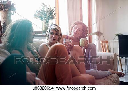 Group of friends, sitting on sofa, drinking tea View Large Photo Image Picture - Group of friends, sitting on sofa, drinking tea. Fotosearch
