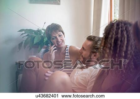 Group of friends, sitting on sofa, relaxing, smiling View Large Photo Image Stock Image - Group of friends, sitting on sofa, relaxing, smiling. Fotosearch