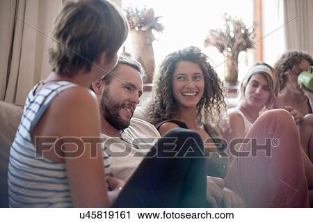 Group of friends, sitting on sofa, relaxing, smiling View Large Photo Image Stock Image - Group of friends, sitting on sofa, relaxing, smiling. Fotosearch