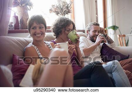 Group of friends, sitting on sofa, drinking tea View Large Photo Image Stock Image - Group of friends, sitting on sofa, drinking tea. Fotosearch