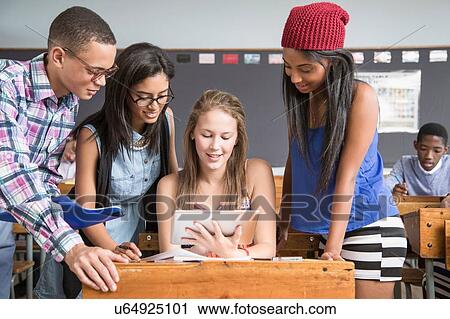 Group of students in classroom, looking at digital tablet View Large Photo Image Stock Image - Group of students in classroom, looking at digital tablet. Fotosearch