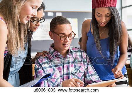 Group of students in classroom, looking at digital tablet View Large Photo Image Stock Image - Group of students in classroom, looking at digital tablet. Fotosearch