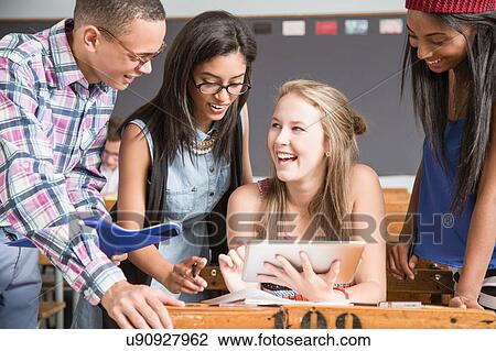 Group of students in classroom, looking at digital tablet View Large Photo Image Stock Image - Group of students in classroom, looking at digital tablet. Fotosearch