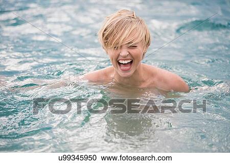 Stock Image - Happy bare shouldered young woman in lake. Fotosearch