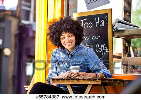 Stock Photo - Happy mature woman drinking takeaway coffee and sidewalk cafe. Fotosearch