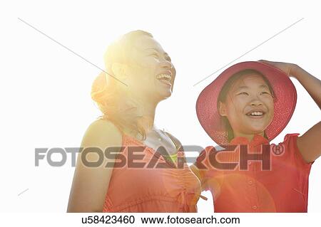 Happy mid adult woman and daughter in sunlight View Large Photo Image Stock Image - Happy mid adult woman and daughter in sunlight. Fotosearch