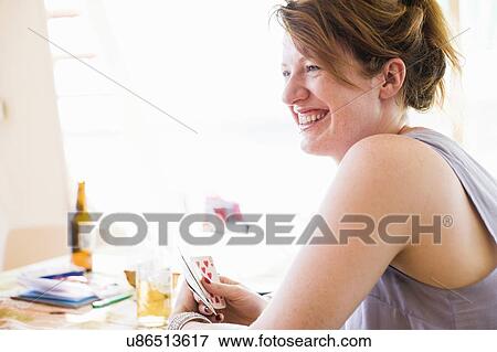 Happy young woman playing card game View Large Photo Image Stock Photo - Happy young woman playing card game. Fotosearch