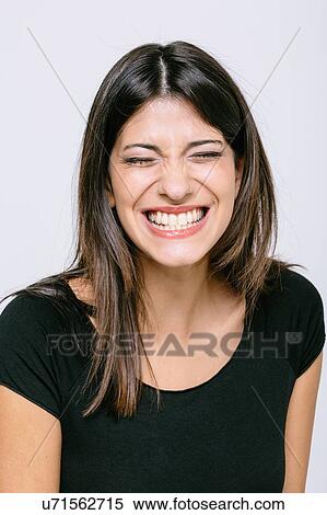 Stock Photography - Head and shoulder portrait of young woman eyes closed toothy smile. Fotosearch