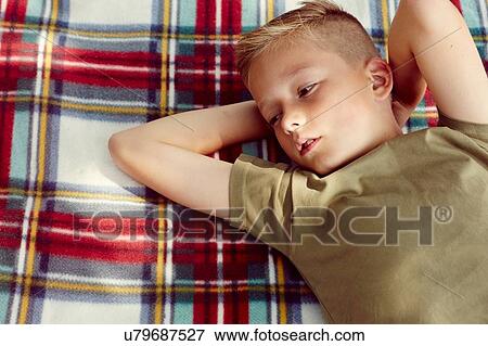 High angle view of boy lying on picnic blanket hands behind head looking away View Large Photo Image Stock Photo - High angle view of boy lying on picnic blanket hands behind head looking away. Fotosearch