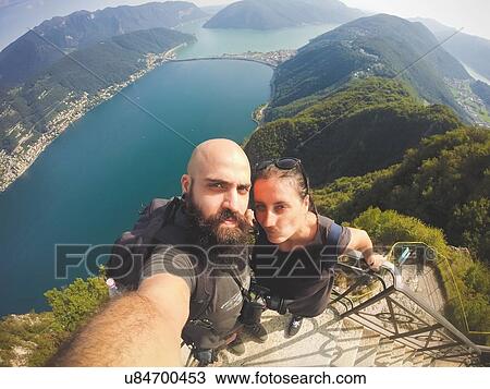 High angle view of mid adult couple taking selfie above Lake Lugano, Switzerland View Large Photo Image Stock Image - High angle view of mid adult couple taking selfie above Lake Lugano, Switzerland. Fotosearch