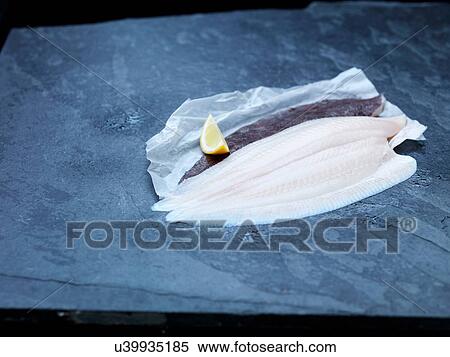 High angle view of raw lemon sole fillet and lemon wedge on baking paper and slate View Large Photo Image Stock Photography - High angle view of raw lemon sole fillet and lemon wedge on baking paper and slate. Fotosearch