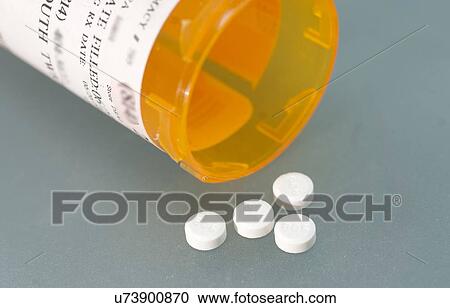 Stock Image - Ivermectin (a broad-spectrum antiparasitic agent) pills and pill bottle. Fotosearch