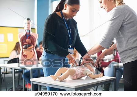 Lecturer giving guidance to college student in Childcare class View Large Photo Image Stock Image - Lecturer giving guidance to college student in Childcare class. Fotosearch