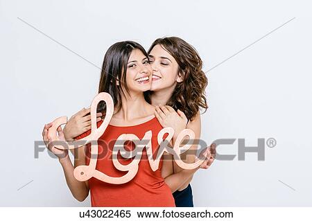 Lesbian couple holding the word love, looking at camera smiling View Large Photo Image Stock Photography - Lesbian couple holding the word love, looking at camera smiling. Fotosearch
