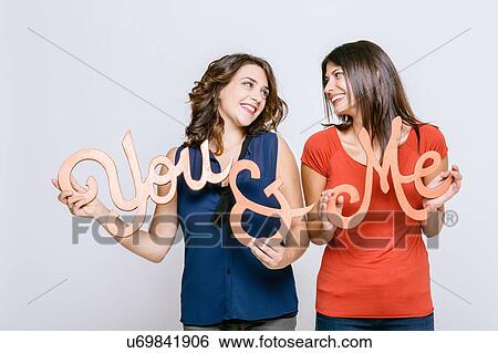 Lesbian couple holding the words you and me face to face smiling View Large Photo Image Stock Photograph - Lesbian couple holding the words you and me face to face smiling. Fotosearch
