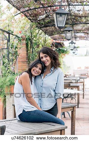 Lesbian couple in plant covered archway head on chest hugging, looking at camera smiling, Florence, Tuscany, Italy View Large Photo Image Stock Image - Lesbian couple in plant covered archway head on chest hugging, looking at camera smiling, Florence, Tuscany, Italy. Fotosearch