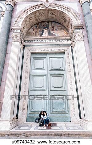 Lesbian couple sitting in oversized church doorway looking at book, Piazza Santa Maria Novella, Florence, Tuscany, Italy View Large Photo Image Stock Image - Lesbian couple sitting in oversized church doorway looking at book, Piazza Santa Maria Novella, Florence, Tuscany, Italy. Fotosearch