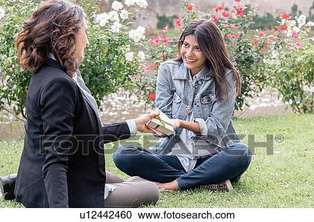 Lesbian couple sitting on grass giving, receiving gift, Florence, Tuscany, Italy View Large Photo Image Stock Image - Lesbian couple sitting on grass giving, receiving gift, Florence, Tuscany, Italy. Fotosearch