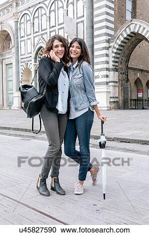 Lesbian couple talking on cellular phone holding umbrella looking at camera smiling, Piazza Santa Maria Novella, Florence, Tuscany, Italy View Large Photo Image Stock Image - Lesbian couple talking on cellular phone holding umbrella looking at camera smiling, Piazza Santa Maria Novella, Florence, Tuscany, Italy. Fotosearch