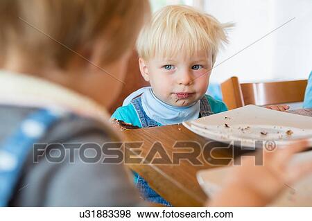 Stock Photo - Male and female toddler at tea table. Fotosearch