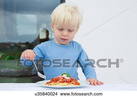 Male toddler eating spaghetti on patio View Large Photo Image Picture - Male toddler eating spaghetti on patio. Fotosearch