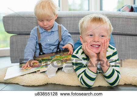 Male toddler reading childrens book on living room floor View Large Photo Image Stock Photo - Male toddler reading childrens book on living room floor. Fotosearch