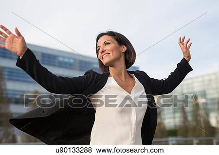 Mature businesswoman celebrating outside office building View Large Photo Image Stock Photo - Mature businesswoman celebrating outside office building. Fotosearch