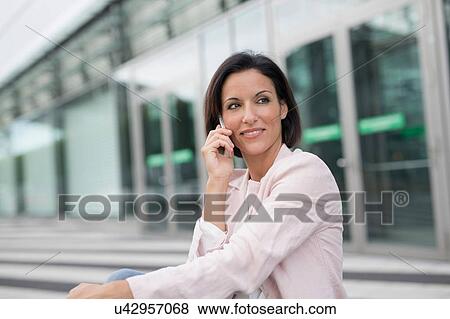 Mature businesswoman chatting on smartphone at airport View Large Photo Image Stock Photo - Mature businesswoman chatting on smartphone at airport. Fotosearch