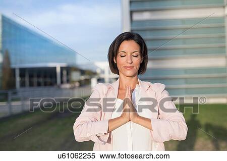 Mature businesswoman practicing yoga outside office building View Large Photo Image Stock Photography - Mature businesswoman practicing yoga outside office building. Fotosearch