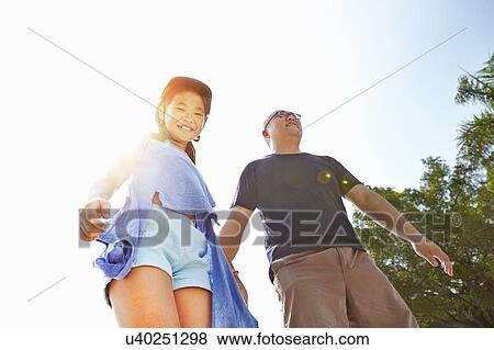 Mature man holding rollerblading daughters hand View Large Photo Image Stock Photo - Mature man holding rollerblading daughters hand. Fotosearch