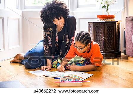 Mature woman and son doing sketchbook homework on living room floor View Large Photo Image Stock Image - Mature woman and son doing sketchbook homework on living room floor. Fotosearch