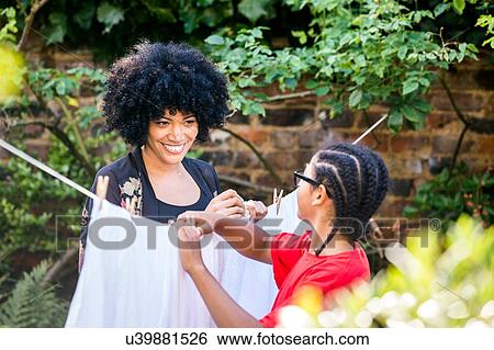 Mature woman and son pegging sheets on garden clothesline View Large Photo Image Stock Photograph - Mature woman and son pegging sheets on garden clothesline. Fotosearch