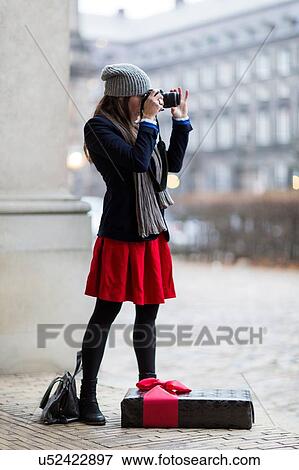 Mature woman with Christmas gift taking photographs of city, Copenhagen, Denmark View Large Photo Image Stock Photo - Mature woman with Christmas gift taking photographs of city, Copenhagen, Denmark. Fotosearch