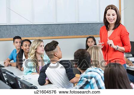 Mid adult female teacher explaining to high school students View Large Photo Image Stock Photograph - Mid adult female teacher explaining to high school students. Fotosearch