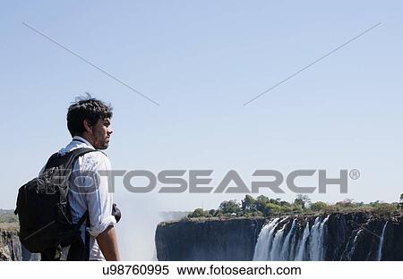 Mid adult man looking out at Victoria Falls, Zambia View Large Photo Image Stock Photography - Mid adult man looking out at Victoria Falls, Zambia. Fotosearch