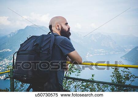 Mid adult man on balcony looking out at Lake Lugano, Switzerland View Large Photo Image Stock Photography - Mid adult man on balcony looking out at Lake Lugano, Switzerland. Fotosearch