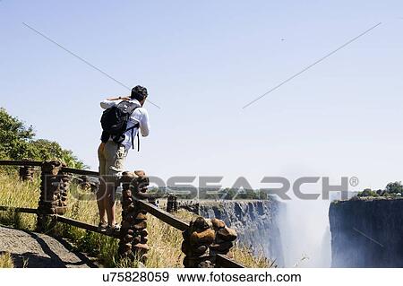 Mid adult man photographing Victoria Falls, Zambia View Large Photo Image Stock Photo - Mid adult man photographing Victoria Falls, Zambia. Fotosearch