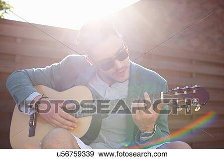 Mid adult man playing guitar at rooftop party View Large Photo Image Stock Photo - Mid adult man playing guitar at rooftop party. Fotosearch