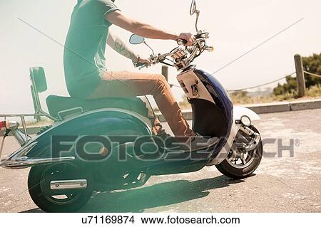 Mid adult man riding moped, low section View Large Photo Image Picture - Mid adult man riding moped, low section. Fotosearch