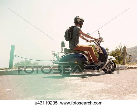 Mid adult man riding moped, rear view View Large Photo Image Stock Photography - Mid adult man riding moped, rear view. Fotosearch
