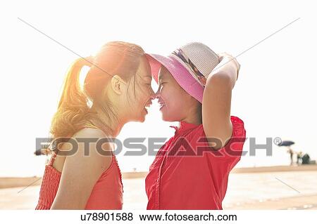 Mid adult woman and daughter face to face on beach, Zhuhai, Guangdong, China View Large Photo Image Stock Photo - Mid adult woman and daughter face to face on beach, Zhuhai, Guangdong, China. Fotosearch