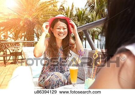 Mid adult woman and daughter having soft drinks at beach cafe, Zhuhai, Guangdong, China View Large Photo Image Stock Photo - Mid adult woman and daughter having soft drinks at beach cafe, Zhuhai, Guangdong, China. Fotosearch