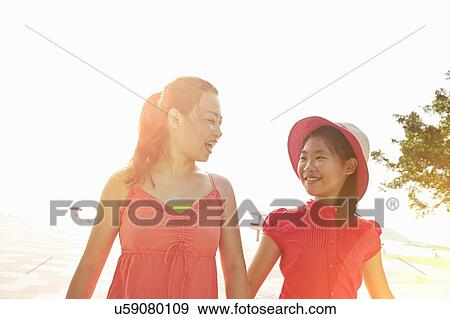 Mid adult woman and daughter strolling on beach, Zhuhai, Guangdong, China View Large Photo Image Stock Photo - Mid adult woman and daughter strolling on beach, Zhuhai, Guangdong, China. Fotosearch