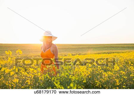 Mid adult woman in canola field wearing sunhat looking away View Large Photo Image Stock Image - Mid adult woman in canola field wearing sunhat looking away. Fotosearch