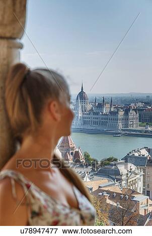 Stock Photo - Mid adult woman looking at view of Buda from the Fisherman's Bastion, Budapest, Hungary. Fotosearch