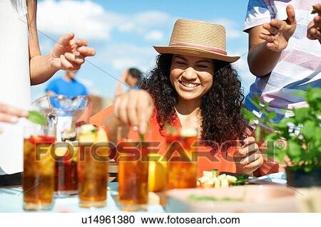Mid adult woman preparing cocktails at rooftop party View Large Photo Image Stock Image - Mid adult woman preparing cocktails at rooftop party. Fotosearch