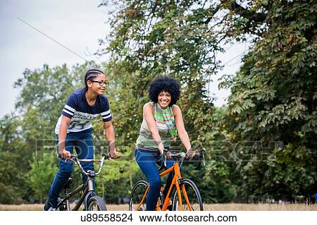 Mother and son riding on bicycles smiling View Large Photo Image Picture - Mother and son riding on bicycles smiling. Fotosearch